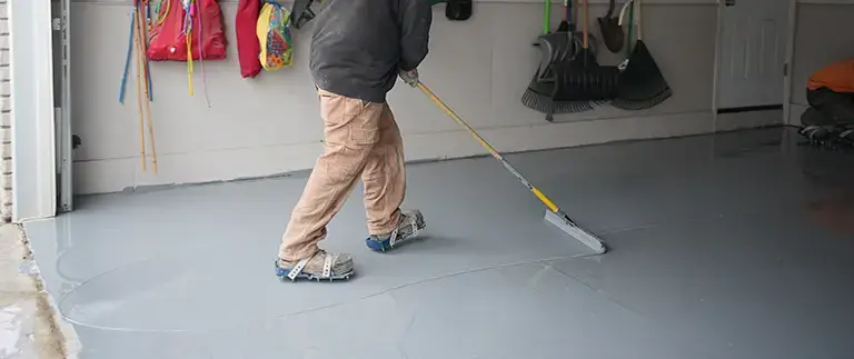 Man spreading epoxy on garage floor